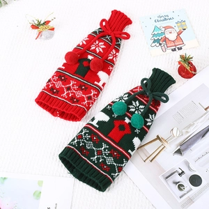 Knitted Christmas wine bottle covers with reindeer and snowflake patterns in red and green