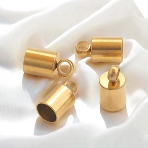 Polished 18K gold-plated stainless steel cord end caps for DIY jewelry on white silk
