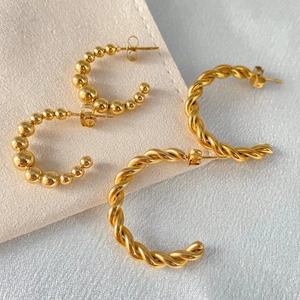 Close-up of gold-plated stainless steel twisted rope and beaded C-shape earrings