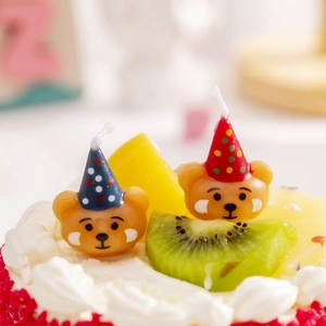 Close-up of cute cartoon bear birthday candles with party hats for cake decoration