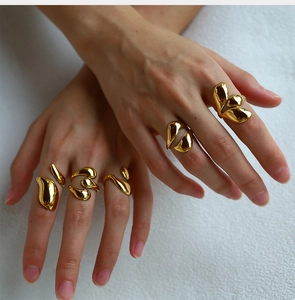 Close-up of elegant gold lava textured adjustable rings worn by a model on white fabric