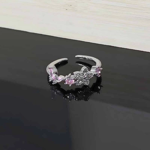 Detailed macro view of pink zircon flower and butterfly motif on silver adjustable ring