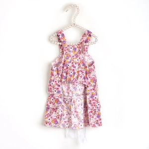 Detailed view of floral pet dress with layered skirt on a pearl hanger