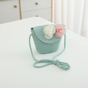 Detail of mint green straw crossbody bag with white and pink 3D flower decorations