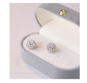 Macro shot of sparkling silver crystal ball stud earrings in a luxury gray velvet box