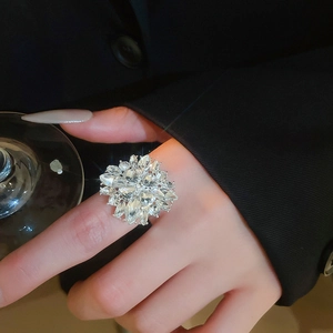 Close-up of a sparkling floral crystal ring worn by a model in a social setting
