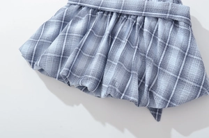 Detail view of blue and white plaid skirt showing breathable seersucker texture and hem