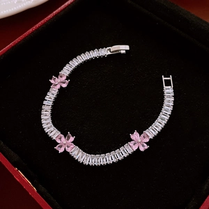 Detailed close-up of zircon heart flower bracelet in a red velvet luxury jewelry box