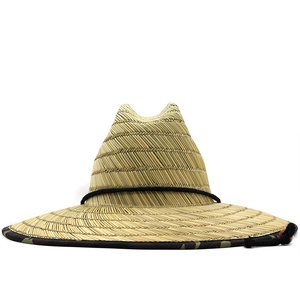 Detailed herringbone weave and wide brim of a straw hat with camouflage edging