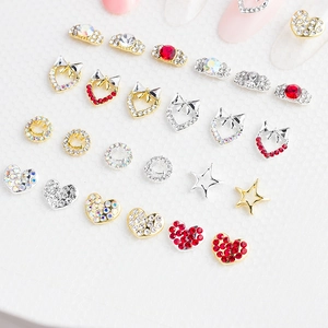 Détail de charmes d'ongles de luxe avec motifs cœur, étoile et nœud en or et argent