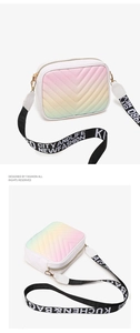Detailed macro view of gradient V-quilted camera bag with wide letter-printed strap