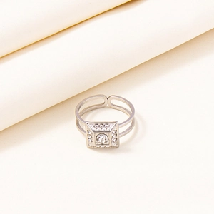 Detail of square geometric silver ring with central crystal and double band design