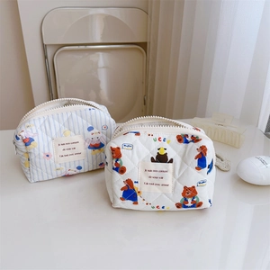 Détail de pochettes matelassées en coton avec motifs de lapin bleu et d'ours blanc
