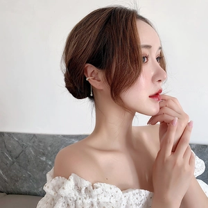 Detailed view of elegant freshwater pearl ear cuff with long chain tassel on woman ear