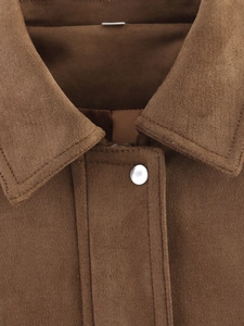 Close-up of vintage brown suede flight jacket collar showing premium stitching details