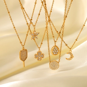 18K gold plated stainless steel necklaces with moon star and clover charms over beige silk