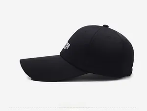 Side view of black baseball cap with extended brim and white embroidery detail