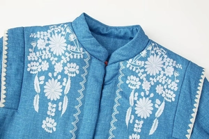 Detail der weißen Blumenstickerei auf blauer Jeansjacke mit hochwertiger Verarbeitung