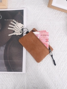 Brown canvas mini coin purse with metal keychain ring and smooth zipper closure