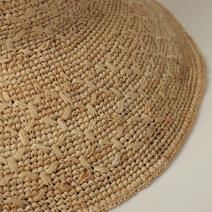 Foldable natural raffia sun hat for women featuring a wide brim and handmade straw weave