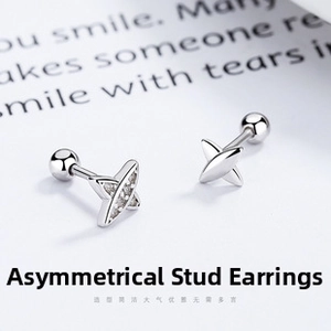 Detailed macro of 925 silver asymmetric cross stud earrings with sparkling zircon stones
