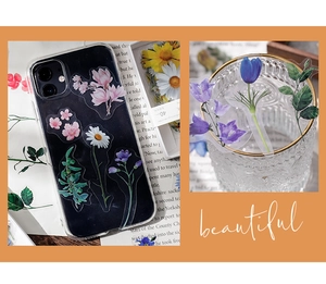 Floral stickers applied on black phone case and glass bottle in a vintage aesthetic style