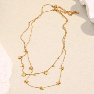 Détail d'un collier multicouche en acier inoxydable doré 18K avec pendentifs fleurs