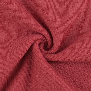 Gros plan sur la texture du tricot rouge montrant le grain fin et le drapé du haut