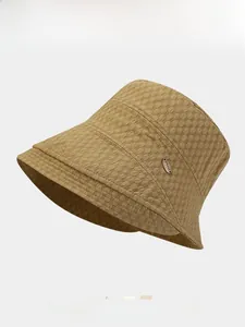 Detail of khaki fisherman hat with bubble texture fabric and small metal logo accent