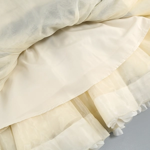 Detailed close-up of the layered tulle hem showing delicate ruffles and light beige mesh fabric