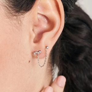 Close-up of S925 sterling silver chain earrings with sparkling zircons for double piercings