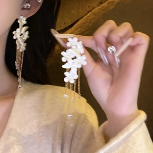 Elegant gold earrings with white flower clusters and long chain tassels for women