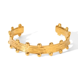 Close-up of 18k gold plated cuff bracelet with bark texture and beaded wave edges
