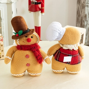 Gingerbread plush dolls with red plaid patterns on wooden table for Christmas decor