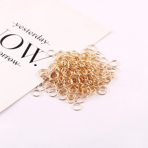 Close-up of numerous gold-colored metal jump rings for DIY jewelry making