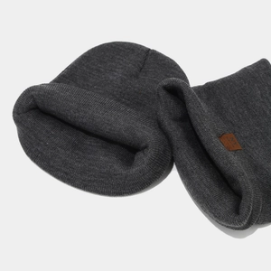 Close-up of charcoal grey knitted beanie featuring a brown NY leather label detail