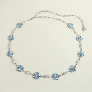 Detailed macro view of silver waist chain featuring blue rhinestone flowers and crystals