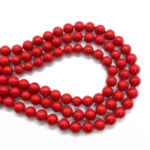 Detailed close-up of glossy red round faux pearl beads for DIY jewelry making