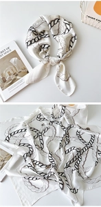 Detail of silk scarf with ivory base and black rope print on art book background