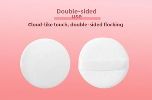 Close-up of two white velvet powder puffs showing soft texture and satin finger ribbon