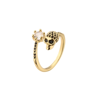 Gold skull ring with clear zircon and black diamonds on a clean white background
