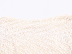 Detailed view of beige mesh fabric with intricate white wavy sequin patterns and texture