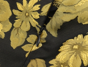 Detalle de la tela de jacquard floral dorado con cremallera invisible negra