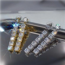 Macro shot of long square-cut cubic zirconia drop earrings in gold and silver finish