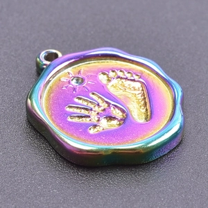 Macro detail of rainbow stainless steel handprint and footprint charm with metallic luster