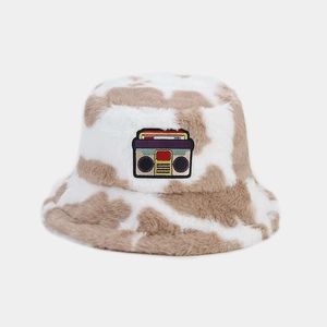 Close-up of cow print plush bucket hat with retro radio embroidered patch detail