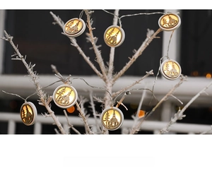 Detail of wooden LED Christmas lights with warm white glow and laser-cut snow scene