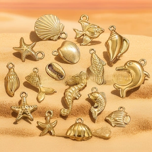 Macro view of golden sea charms featuring starfish, shells and dolphin for DIY jewelry