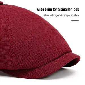 Deep red newsboy cap with textured fabric and wide brim shown from a side profile