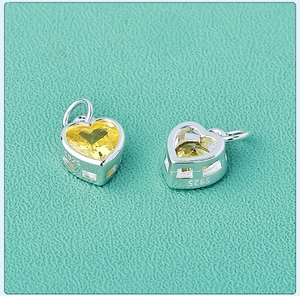 Macro shot of S925 sterling silver heart pendant with vibrant yellow zircon stone